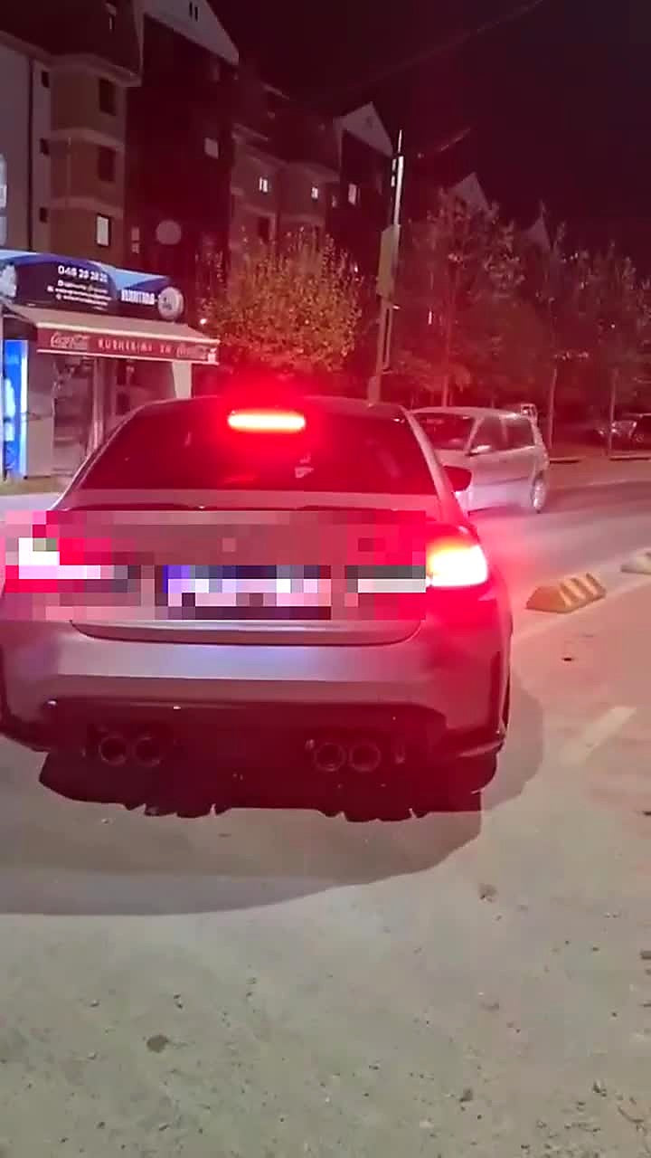 Frozen grey BMW M3 G80 rear view at night on a residential street, carbon diffuser with four exhaust tips, titanium valved catback fitted, number plate pixelated for privacy