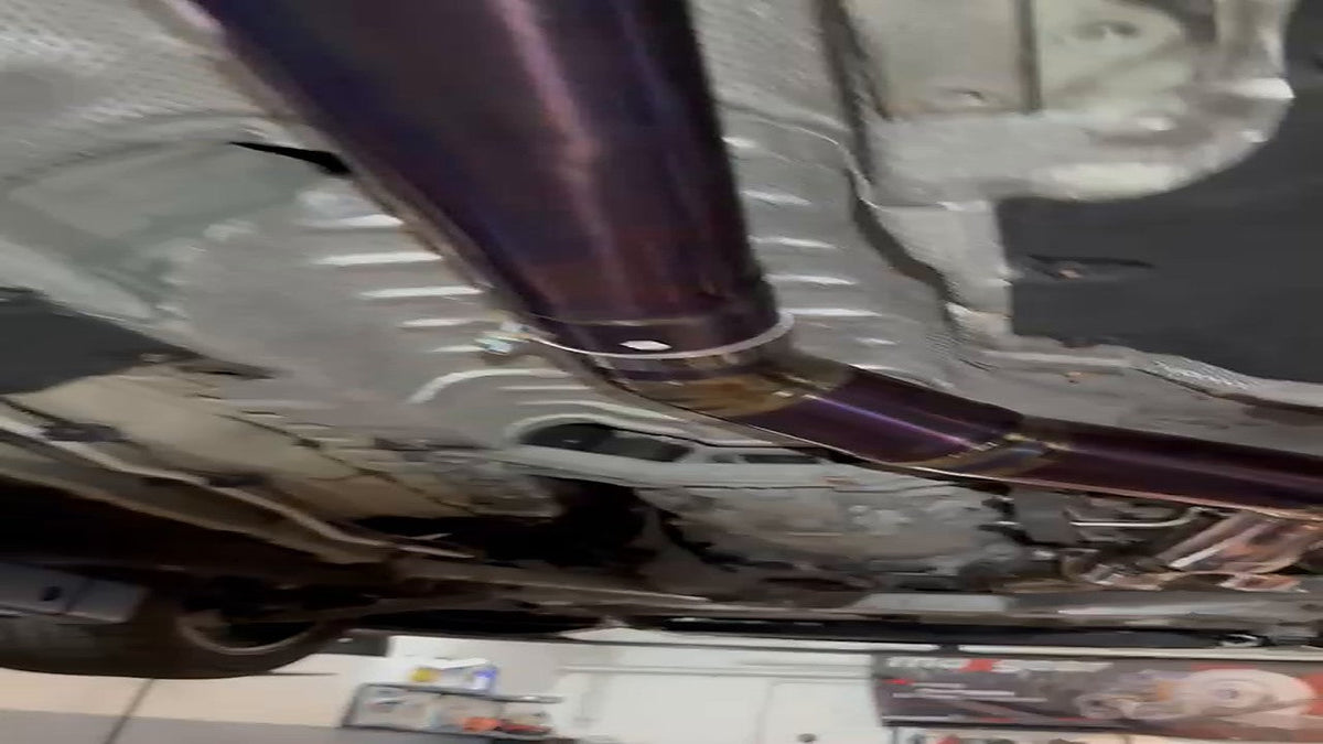 BMW M4 F82 rear three-quarter, titanium single-tube valved catback fitted, no readable number plate visible in frame