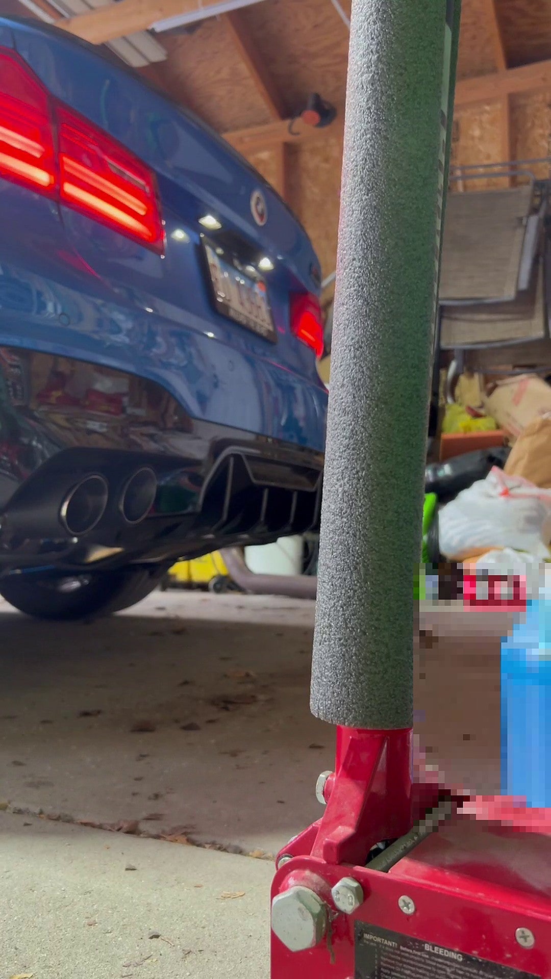 BMW M5 F90 (F90) rear three-quarter on the road, titanium valved cat-back fitted, no readable number plate visible in frame
