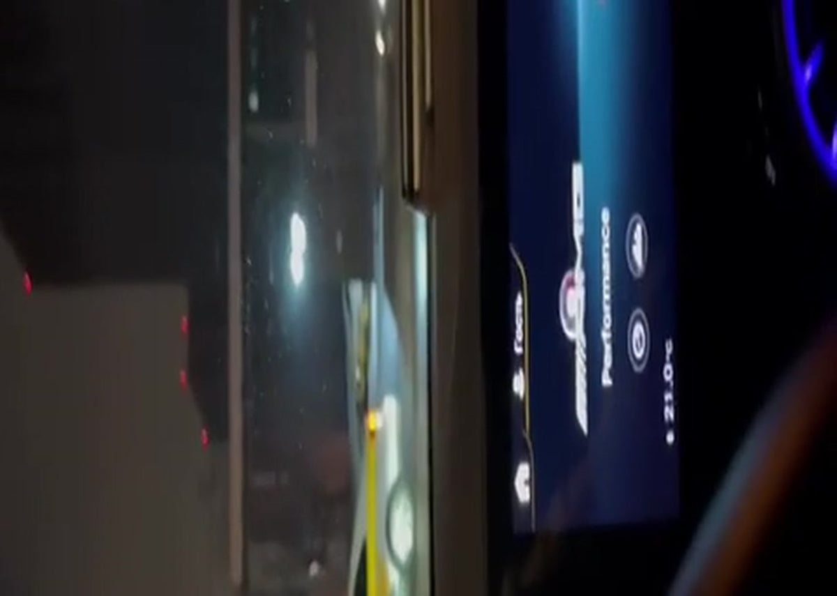 Mercedes-AMG A35 W177 cockpit at night, MBUX screen showing the Performance menu, road visible through the windscreen